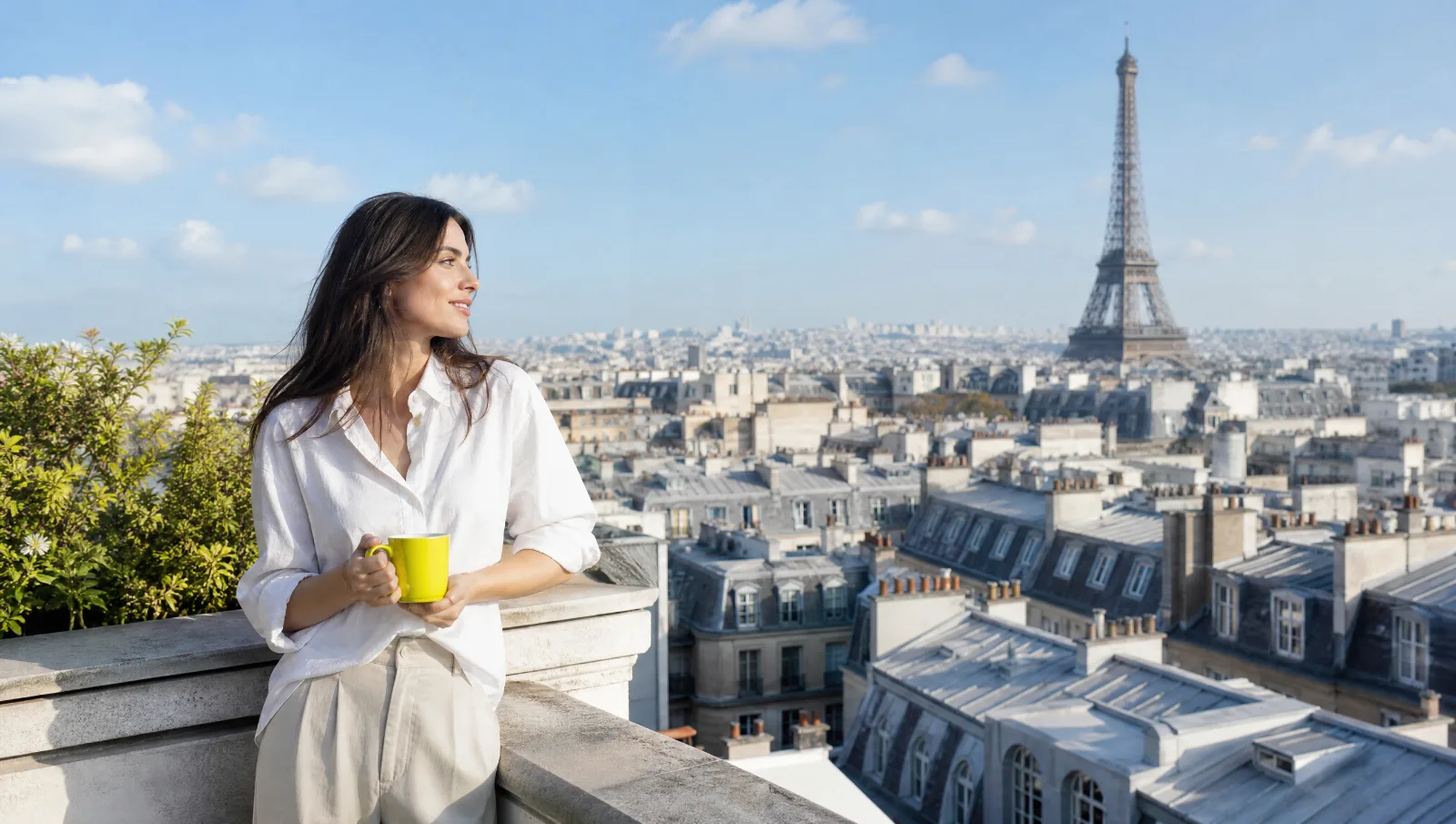 Femme sur un balcon avec vue sur la tour Eiffel